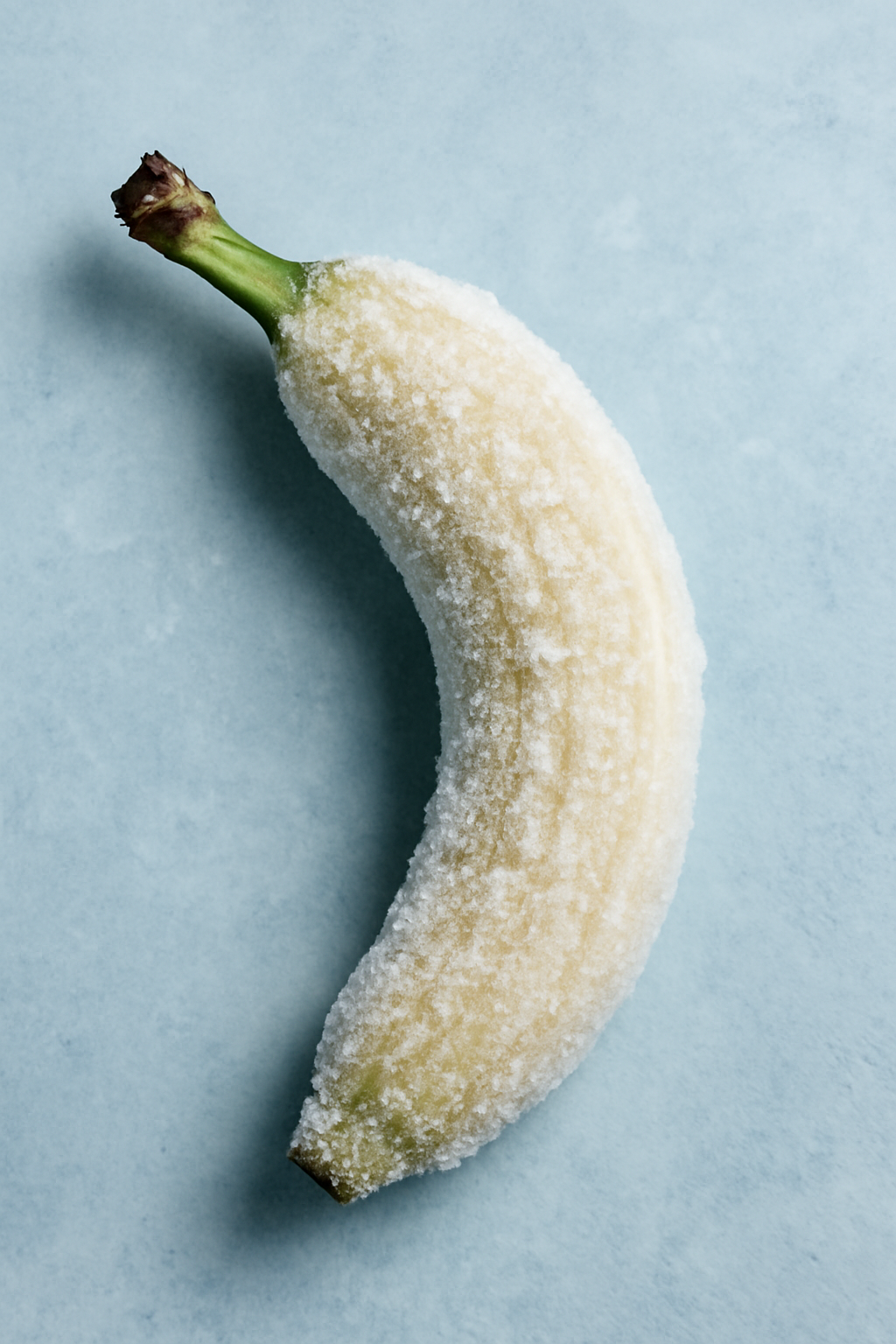 Une banane givrée, rêveuse de neige, se penche en silence, étreignant l'hiver, tandis que l'été danse au fond des souvenirs éclatés.